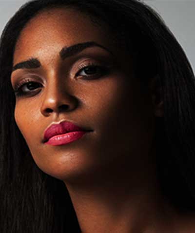 African American wearing Brazilian Carnaval lipstick by Plum & York